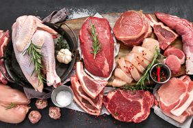 Different types of raw meat - beef, pork, lamb, chicken on dark background