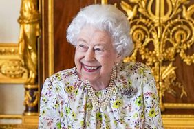 Britain's Queen Elizabeth II smiles as she arrives to view a display of artefacts from Halcyon Days to commemorate the company's 70th anniversary in the White Drawing Room at Windsor Castle on March 23, 2022.