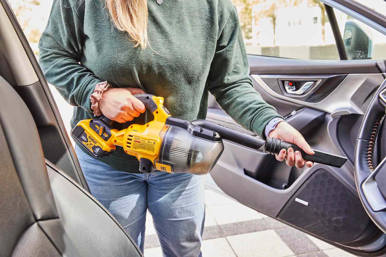 Person adding the crevice attachment to the Dewalt 20-Volt Cordless Handheld Vacuum