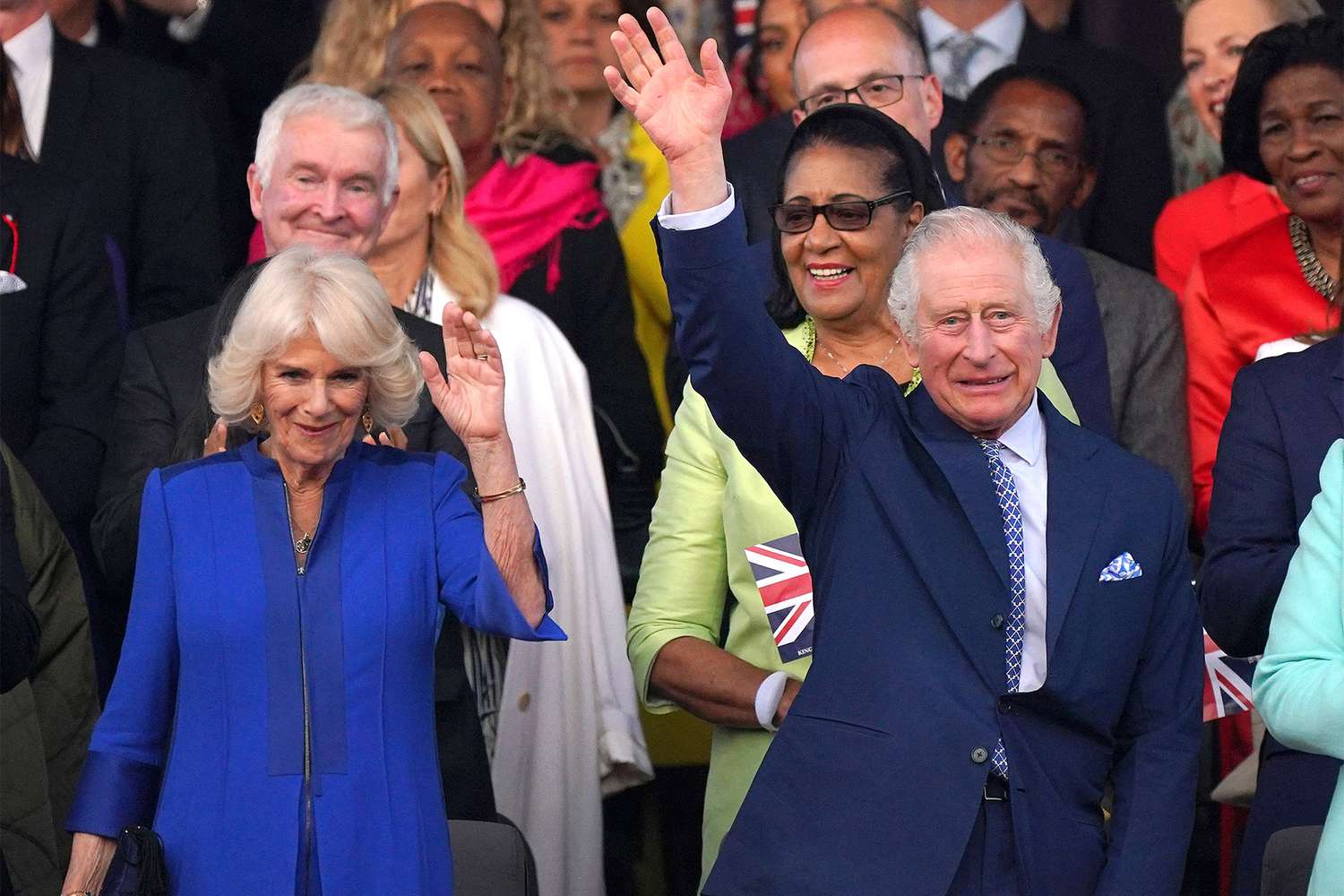 Britain's King Charles III (R) and Britain's Queen Camilla wave as they arrive to attend the Coronation Concert at Windsor Castle in Windsor, west of London on May 7, 2023. - For the first time ever, the East Terrace of Windsor Castle will host a spectacular live concert that will also be seen in over 100 countries around the world