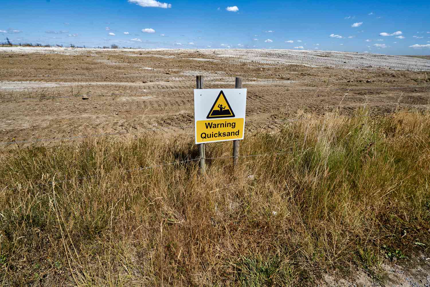 Warning Quicksand sign on a field near the River Thames Estuary in Essex County England UK.