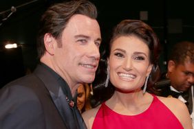 John Travolta (R) and Idina Menzel present an award on stage at the 87th Oscars