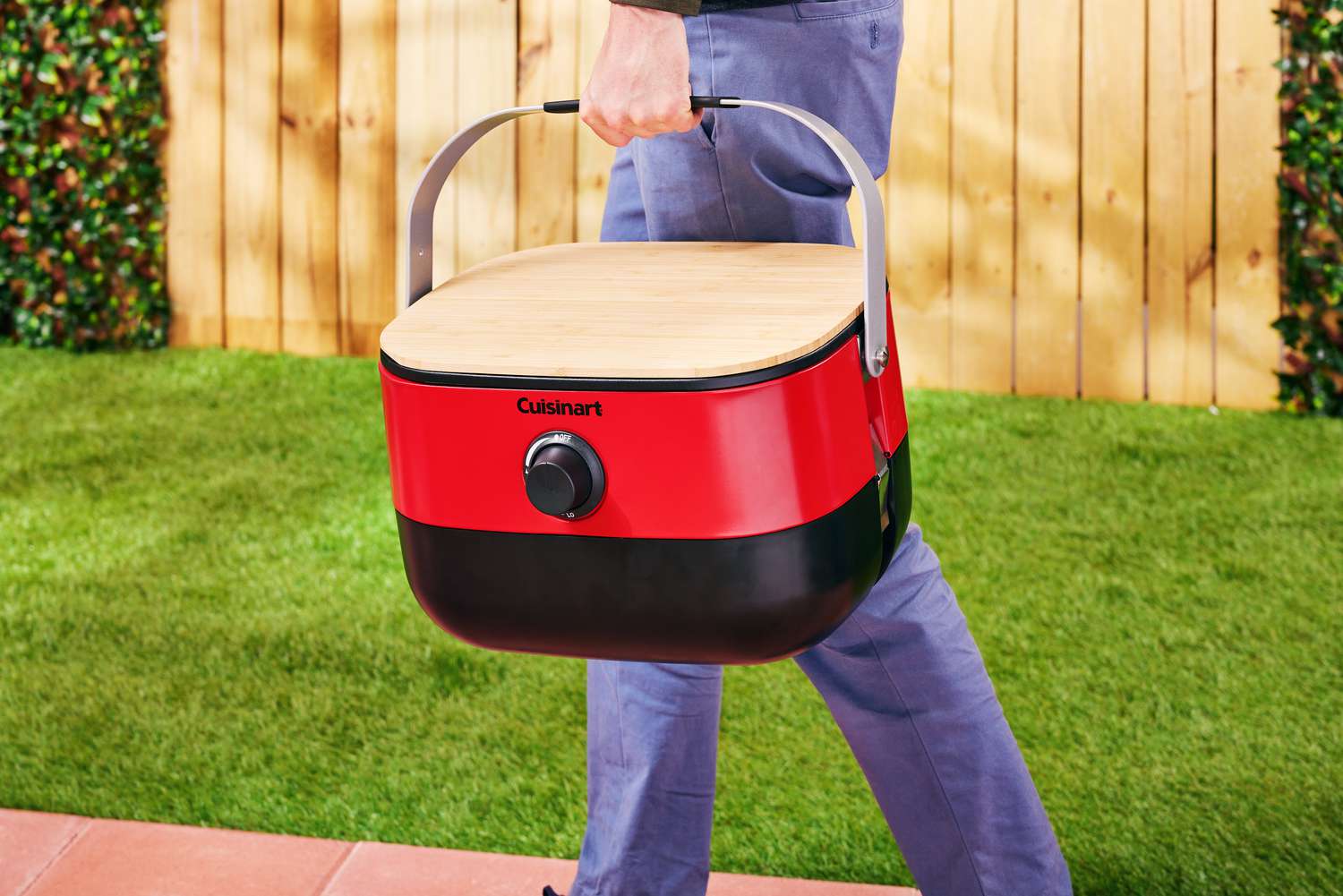 Person holding Cuisinart Venture Portable Gas Grill while walking