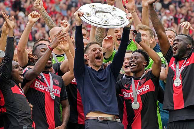 Leverkusen head coach Xabi Alonso celebrates with his team after winning the Bundesliga