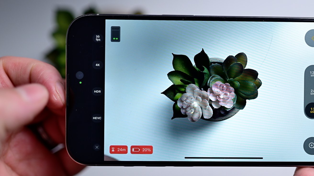 A closeup shot of the Final Cut Camera app that shows video resolution, frame rate, HDR, and format on the left side of the screen above a white table