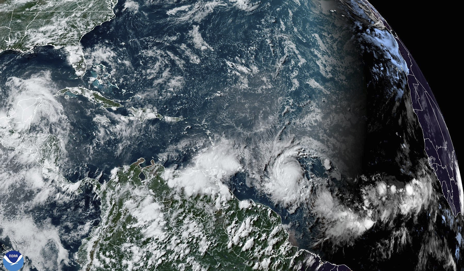 This National Oceanic and Atmospheric Administration satellite image taken at 4:20pm EDT shows hurricane Beryl, lower center right, as it strengthens over the Atlantic Ocean and churns toward the southeast Caribbean on Saturday, June 29, 2024. (NOAA via AP)