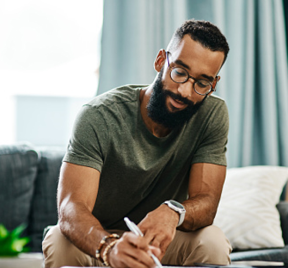 Man writing down information about his car insurance.