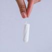 Woman's hand holding clean cotton tampon close-up. Young woman preparing menstruation time. Soft tender protection woman critical days, gynecological. Medical hygiene conception and protection