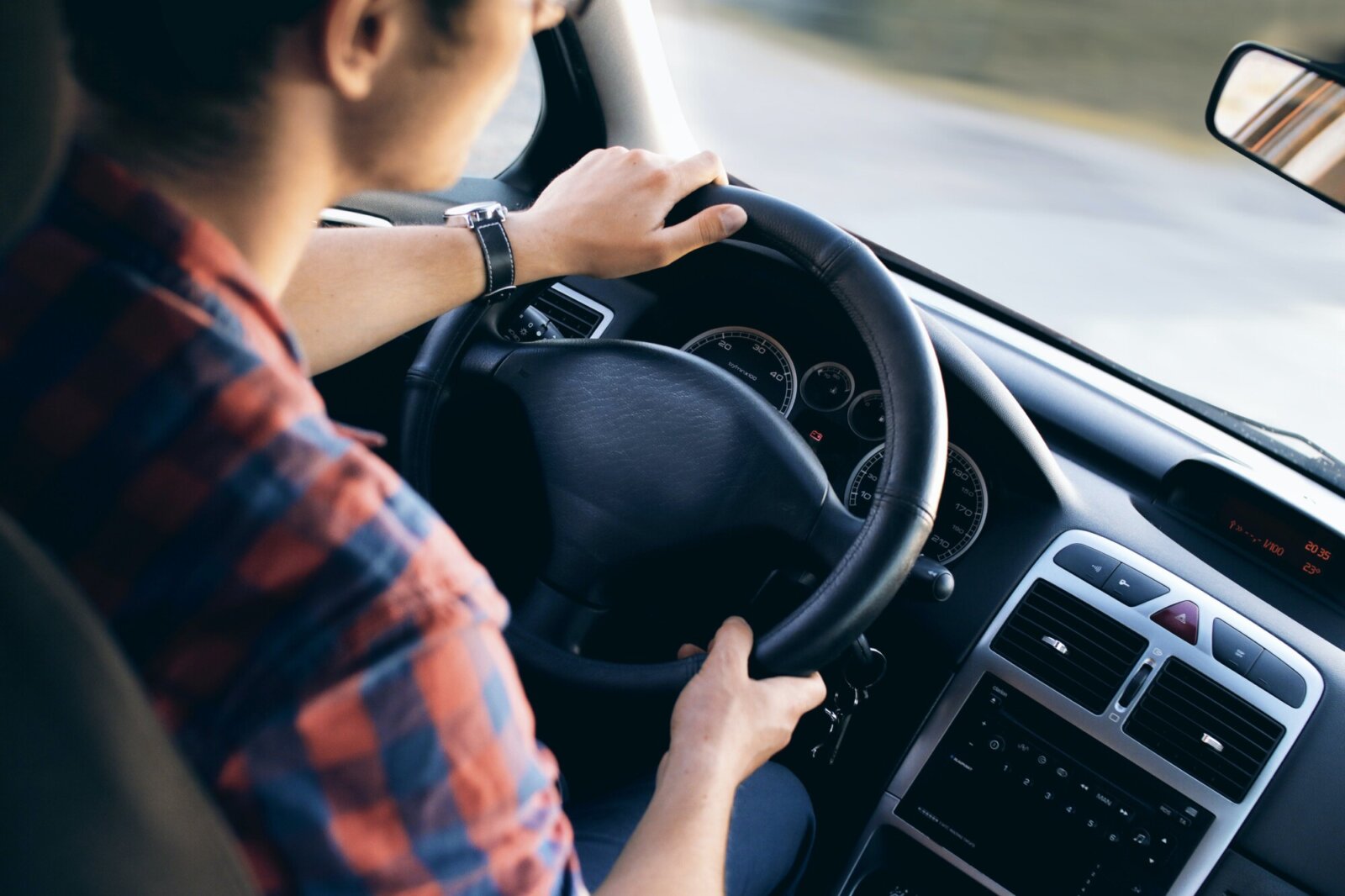 person turning a steering wheel