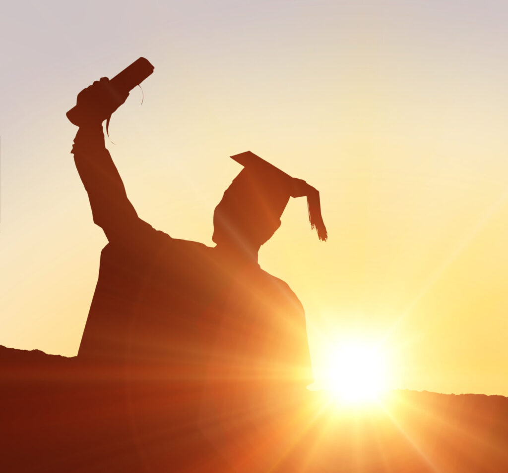 Silhouette of graduate against sun shining