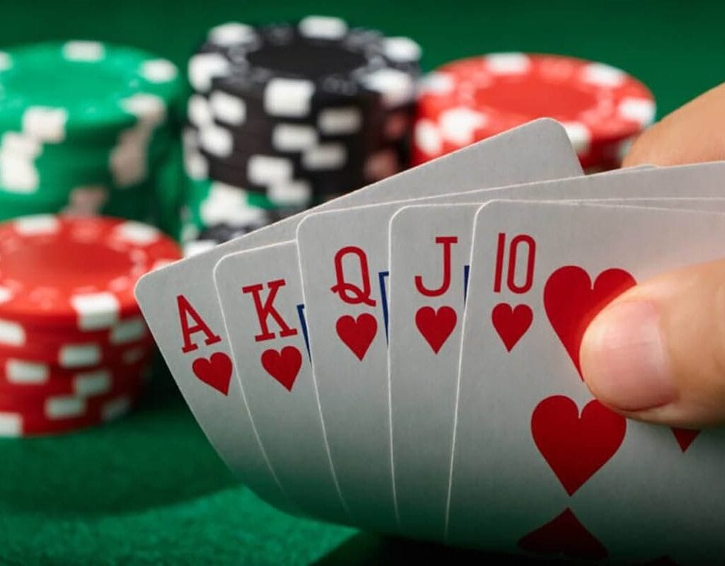 poker player showing a royal flush with casino chips in the background