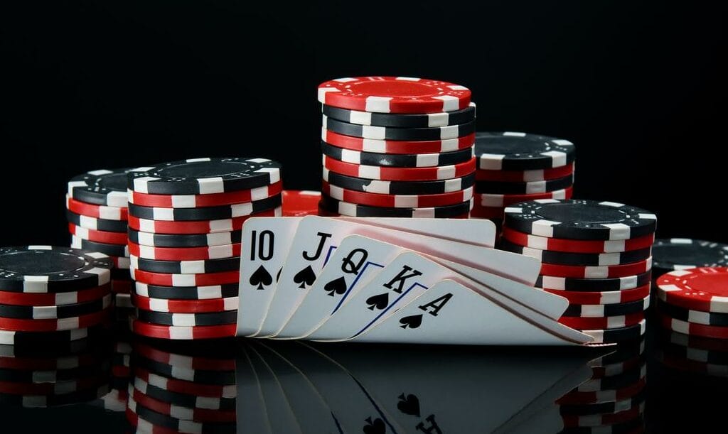 Poker chips and cards against a black background.