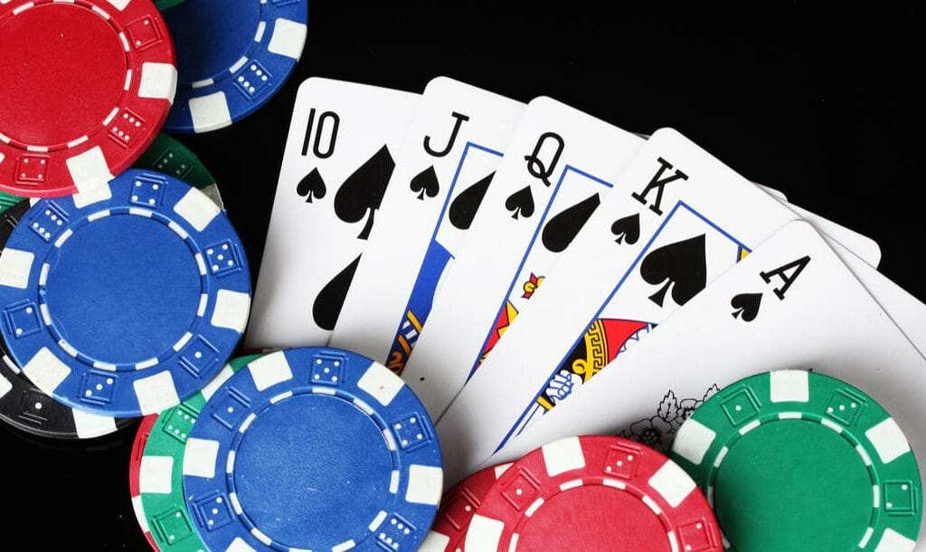 A royal flush and poker chips on a casino table.