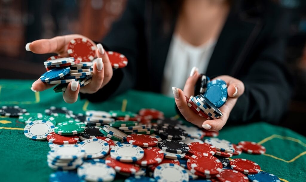 A woman holds poker chips in her hands