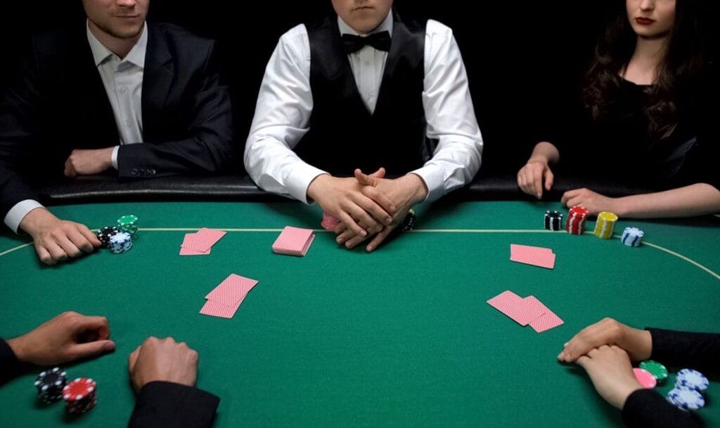 A group of well-dressed people sitting around a poker table.