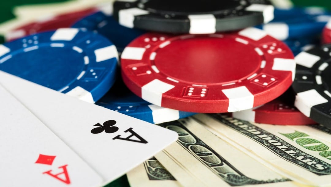 American dollars and Ace playing cards with red and black casino chips.