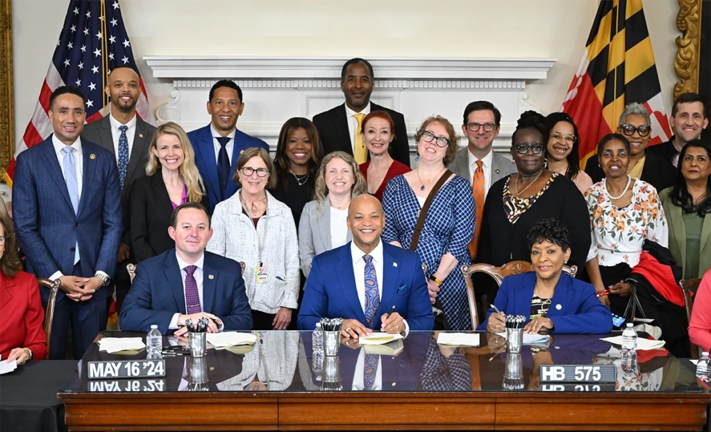 Governor Wes Moore and community leaders smiling.