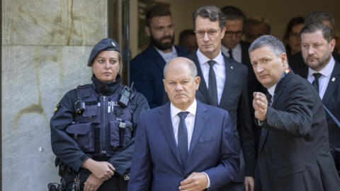 German Chancellor Olaf Scholz, center and Hendrik Wüst, background center, Minister President of North Rhine-Westphalia, near the scene of a knife attack in Solingen, Germany.