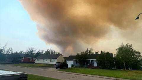 Smoke from an encroaching wildfire is seen over homes after an evacuation was ordered in the eastern Canadian community of Labrador City, Newfoundland, Canada July 12, 2024.