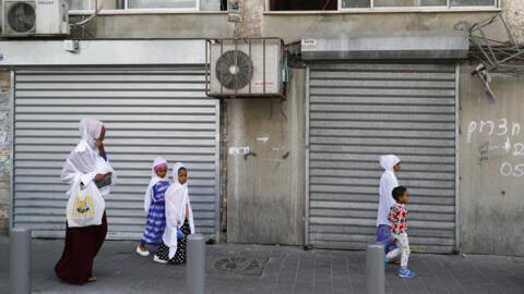 In this file photo, immigrants from Eritrea are seen walking in the Israeli city of Tel Aviv on April 5, 2018.