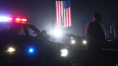 An officer stands at his car early Sunday, July 14, 2024, closing access to the site of the rally where former President Donald Trump was the target of an assassination attempt on Saturday in Butler,