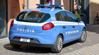 Mașină a poliției italiene parcată lângă o clădire.