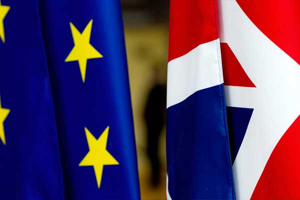 The European Union flag and the UK's Union Jack flying next to each other. 