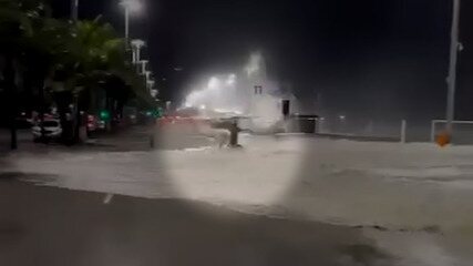Água do mar invade as pistas da Avenida Delfim Moreira, no Leblon, e derruba cliclista