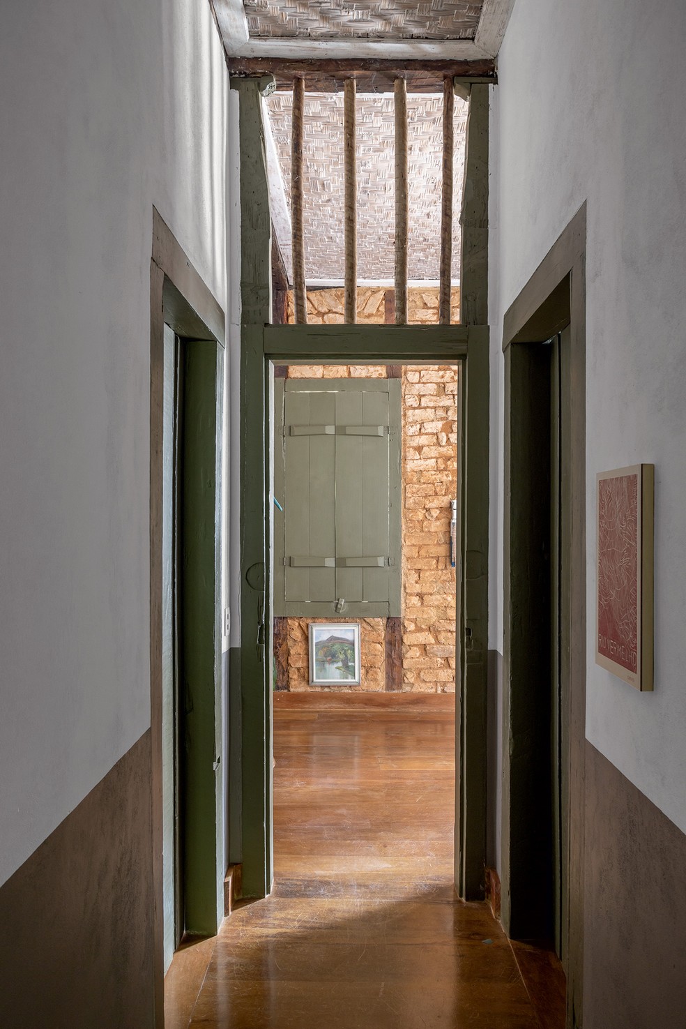 CORREDOR | A vista do corredor para a sala mostra o piso de madeira que reveste a casa, da Guará Planejados, e contrasta com o verde dos batentes — Foto: Evelyn Müller / Divulgação