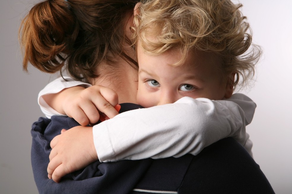 Criança triste no colo da mãe (Foto: Shutterstock) — Foto: Crescer