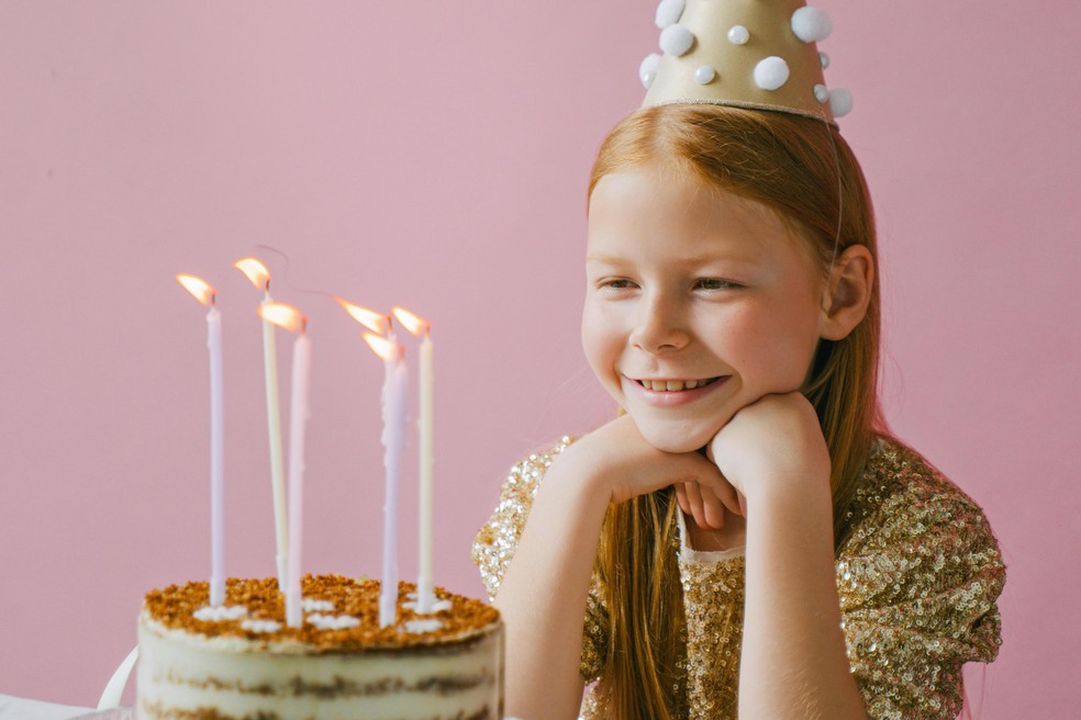 Menina feliz com bolo de aniversário — Foto: Pexels/Ivan Samkov