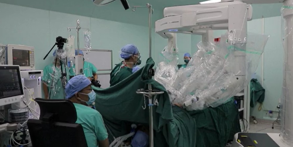 Médicos chineses observam cirurgia feita remotamente com o auxílio de braços robóticos — Foto: CCTV/Reprodução