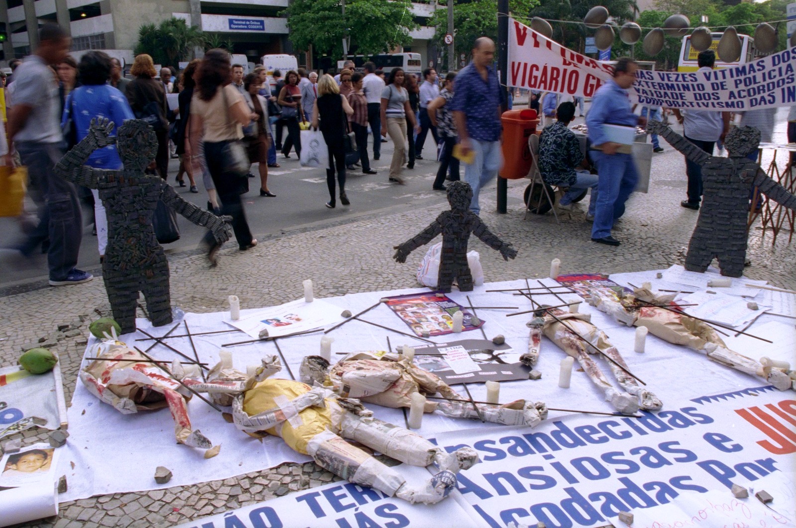 Com bonecos de papel estendidos sobre faixas, parentes e amigos das vítimas da chacina de Vigário Geral realizam manifestação em frente ao Fórum, antes do julgamento de mais um dos acusados da chacina, o ex-PM Roberto Cesar do Amaral Júnior. Ele negou sua participação no assassinato de 21 pessoas, em agosto de 1993 — Foto: Ivo Gonzalez / Agência O Globo