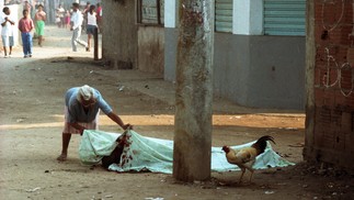 Uma moradora observa o corpo de uma das vítimas da chacina, em 30 de agosto de 1993  — Foto: André Durão / Agência O Globo