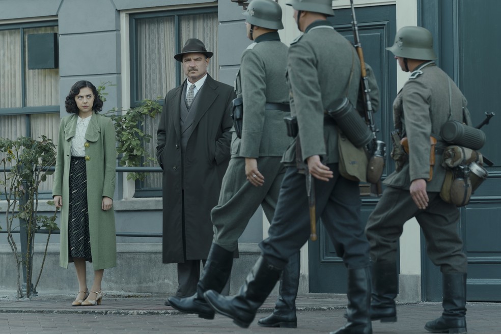 Cena da série em que Miep Gies [Bel Powley] e Otto Frank [Liev Schreiber] observam a chegada dos oficiais nazista a Amsterdã, após a invasão da Holanda — Foto: Divulgação/NatGeo