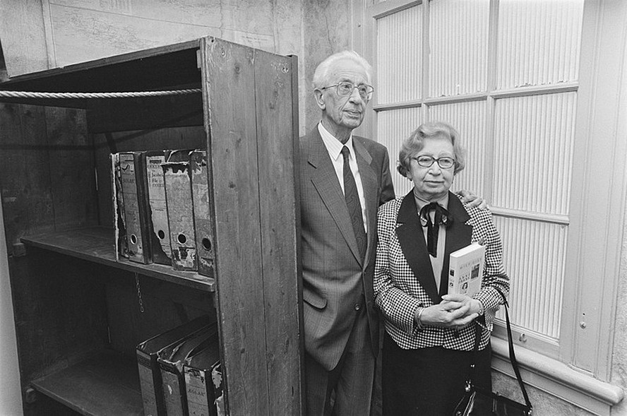 Miep e Jan Gies, em sua velhice, na entrada do anexo secreto, atrás de uma estante