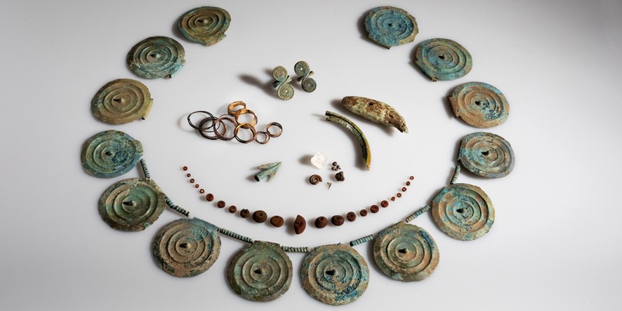 O tesouro da Idade do Bronze inclui um colar feito de discos de bronze espinhados, anéis, contas de âmbar, uma ponta de flecha e um dente de urso