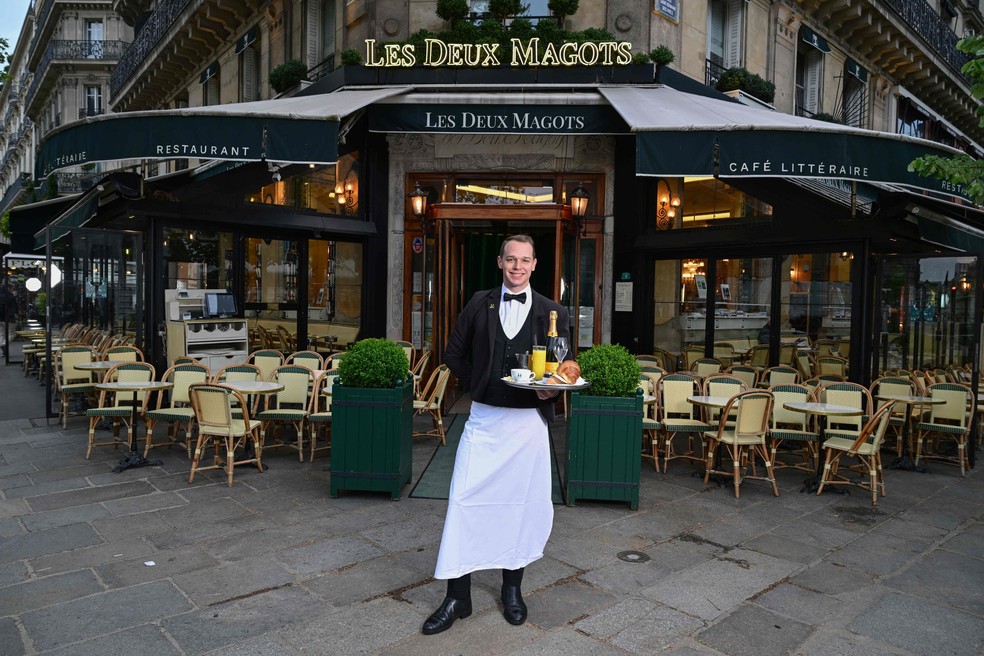 Garçom do Les Deux Magots, um dos restaurantes mais tradicionais de Paris, fundado em 1884, e que estará aberto durante os Jogos Olímpicos de 2024 — Foto: Miguel Medina / AFP