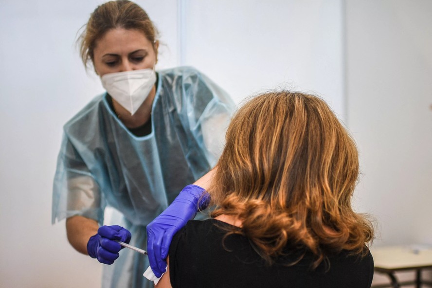 Funcionária do SNS aplica vacina em uma pessoa em Lisboa durante a pandemia de Covid-19
