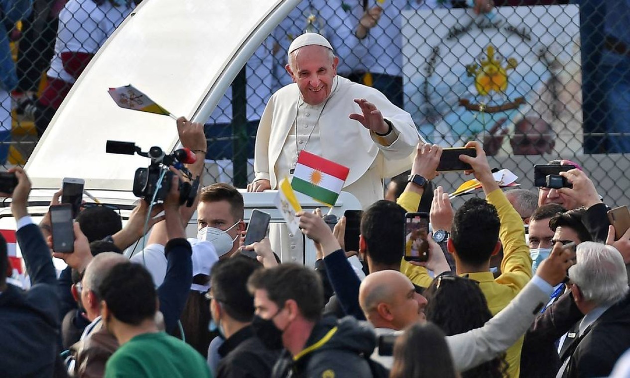 RESPEITO - O Papa Francisco abençoa as pessoas ao chegar de papamóvel na capital da região autônoma Curda do norte do Iraque. A viagem histórica tem compromissos com as comunidades cristãs que suportaram a brutalidade do grupo do Estado Islâmico  — Foto: VINCENZO PINTO / Agência O Globo