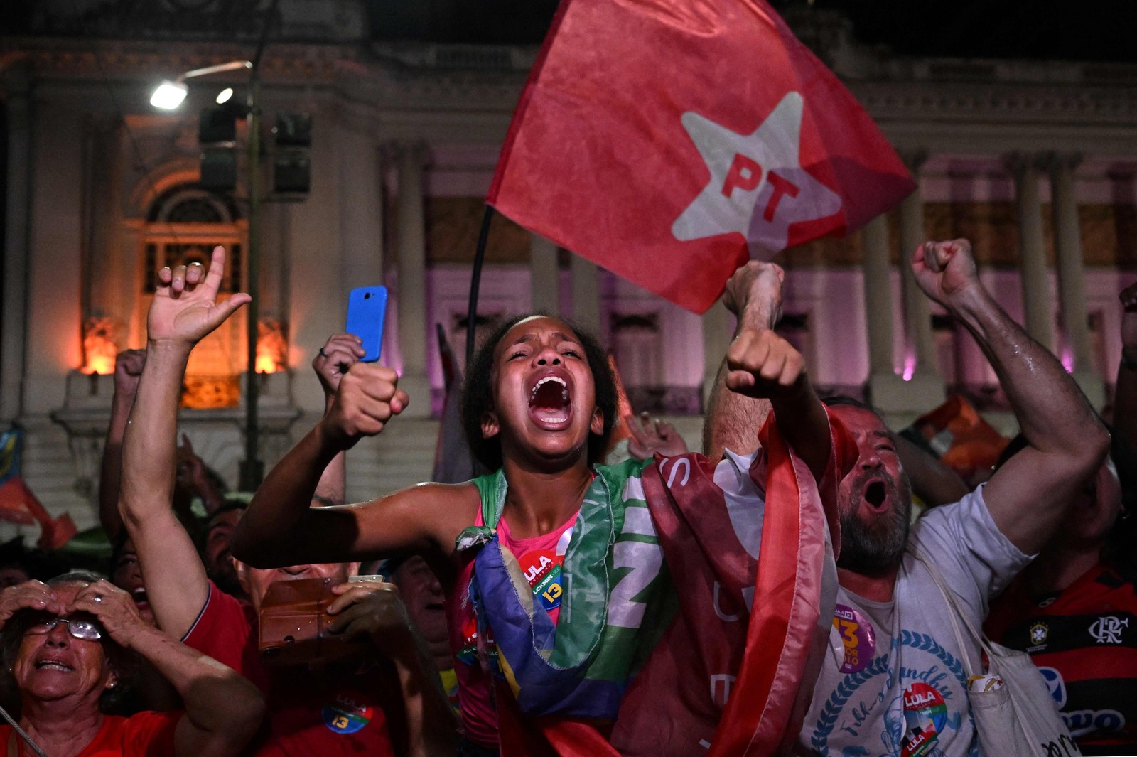 Apoiadores do ex-presidente brasileiro e candidato do Partido dos Trabalhadores (PT) Luiz Inácio Lula da Silva comemoram depois da vitória no segundo turno das eleições presidenciais, no Rio de Janeiro, em 30 de outubro.  — Foto: Pablo PORCIUNCULA / AFP