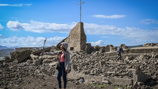 Vestígios da cidade centenária de Pantabangan ressurgiram no norte das Filipinas após o nível da água da barragem baixar em meio a uma seca que assola muitas partes do país — Foto: JAM STA ROSA / AFP