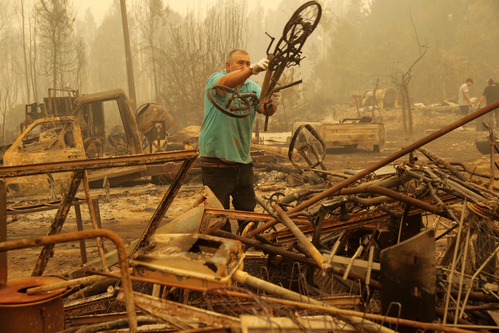 Um homem limpa uma área afetada pelos incêndios florestais no Chile. — Foto: JAVIER TORRES / AFP