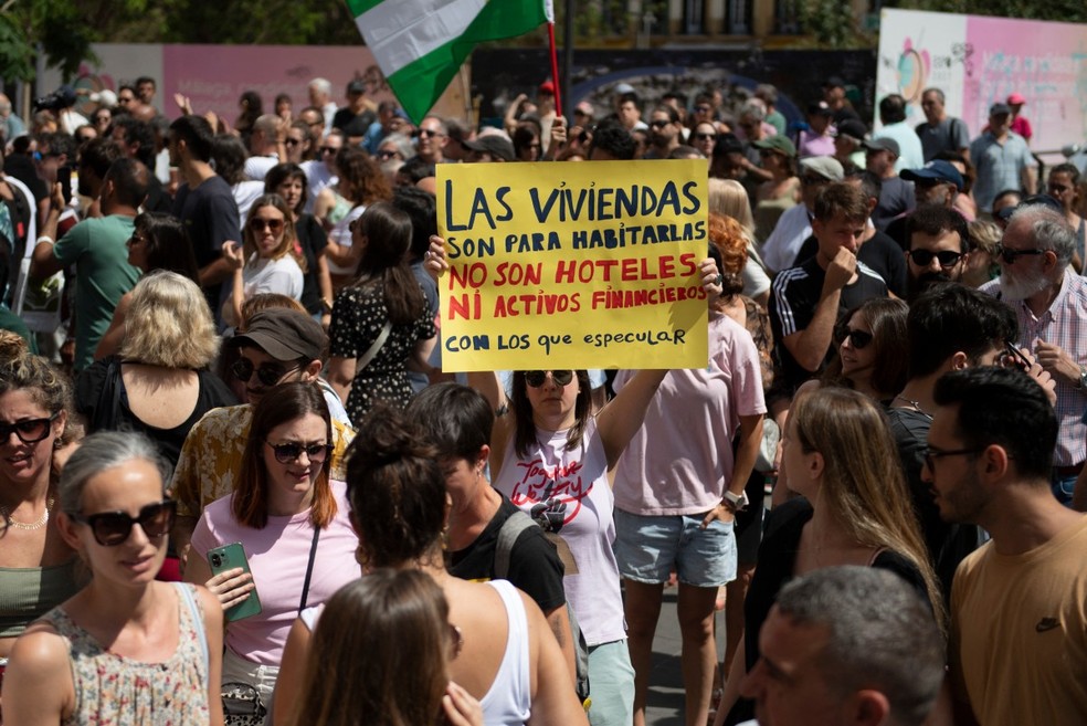 “Casas são feitas para morar, não hotéis ou ativos financeiros para especular”, diz cartaz de manifestante espanhol contra o turismo em massa — Foto: JORGE GUERRERO/AFP