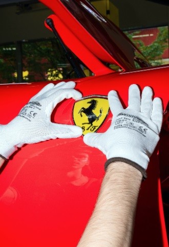 Funcionário coloca o símbolo ícone da Ferrari no chassi de um automóvel que está sendo montado na nova fábrica da montadora na Itália — Foto: Maurizio Fiorino/The New York Times