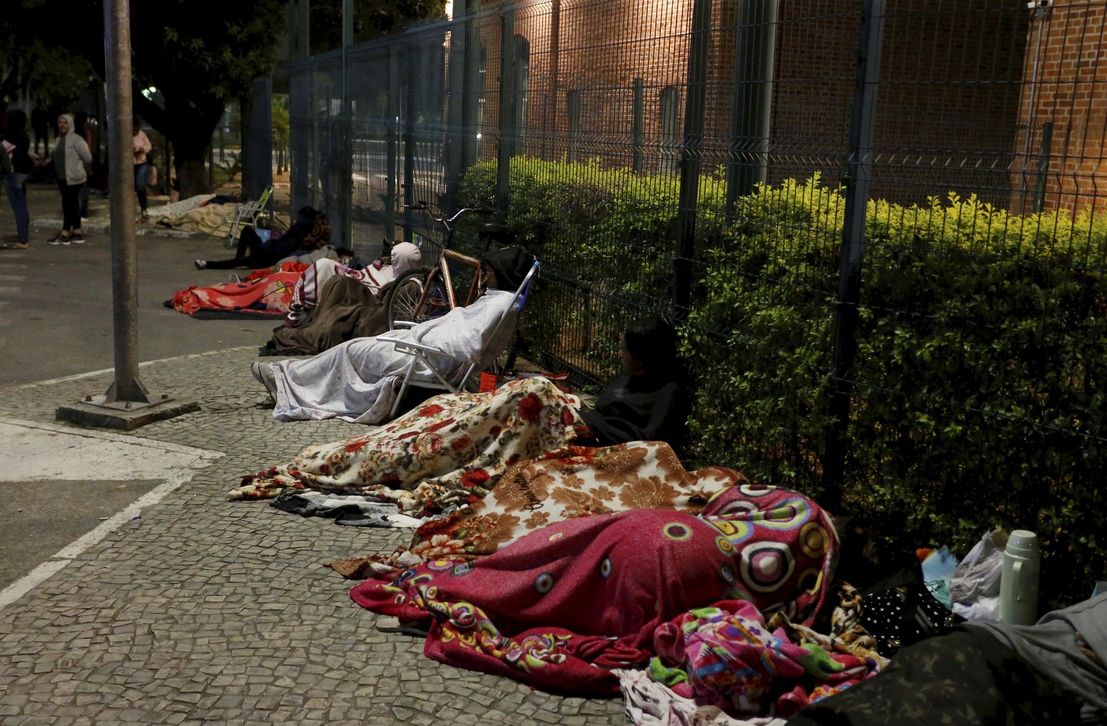 A fila se formou na noite anterior ao começo do atendimento. Muitos dormiram ao relento, incluindo crianças — Foto: Fabiano Rocha / Agência O Globo
