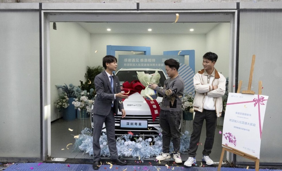 Compra de um carro elétrico BYD por um cliente é comemorada em uma concessionária de automóveis em Shenzhen, China — Foto: Gilles Sabrié/The New York Times