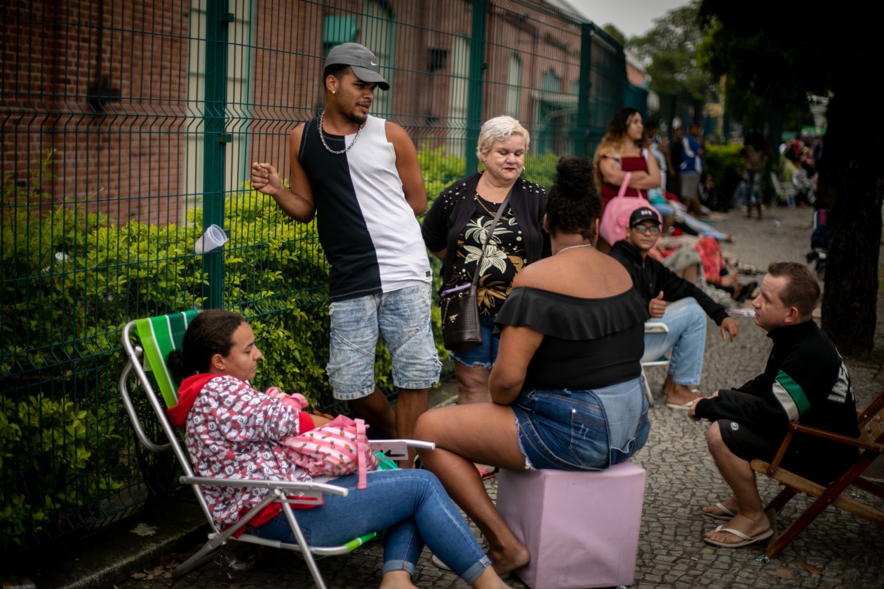 Pessoas tentam se acomodar na fila à espera do recadastramento do CadÚnico no Poupa Tempo em Bangu, Zona Oeste do Rio — Foto: Brenno Carvalho/Agência O Globo