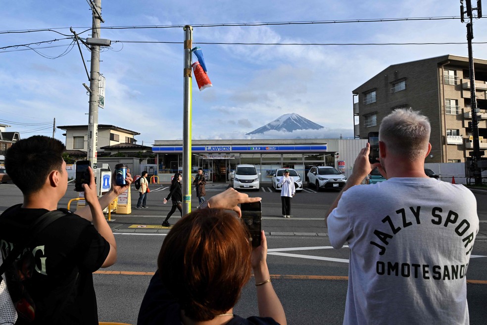 Moradores reclamam da desordem causada pelos turistas na caça ao melhor ângulo do Monte Fuji — Foto: Kazuhiro NOGI / AFP