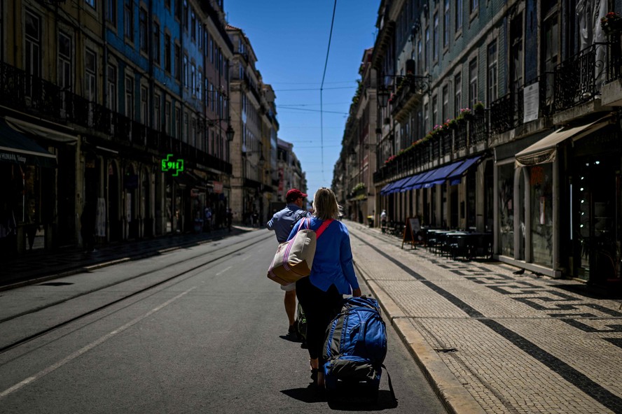 Turistas puxam suas malas pelo centro de Lisboa